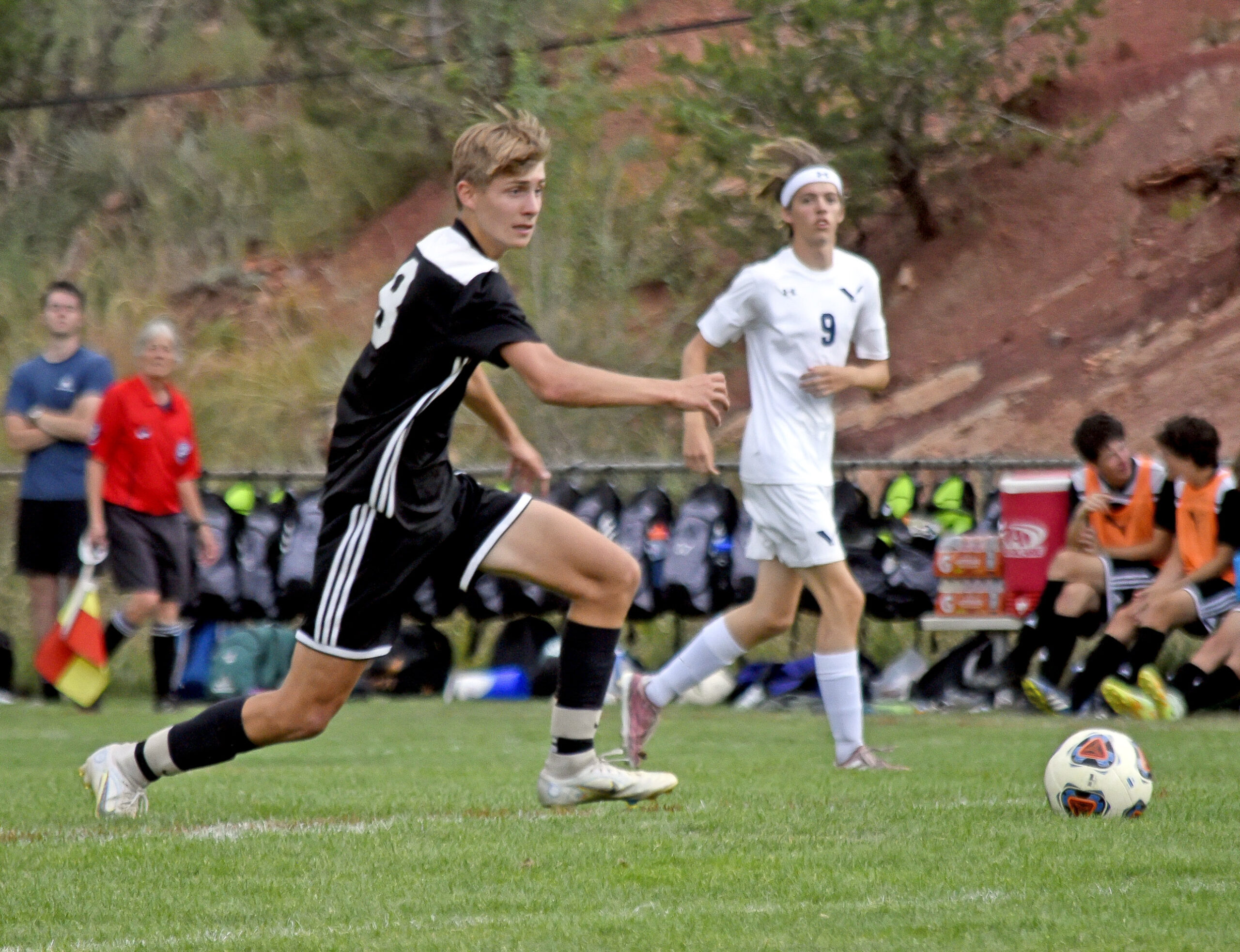 Photo by Bryan Oller. Mustang Evan Yount races to the ball before a Vanguard player can get to it.