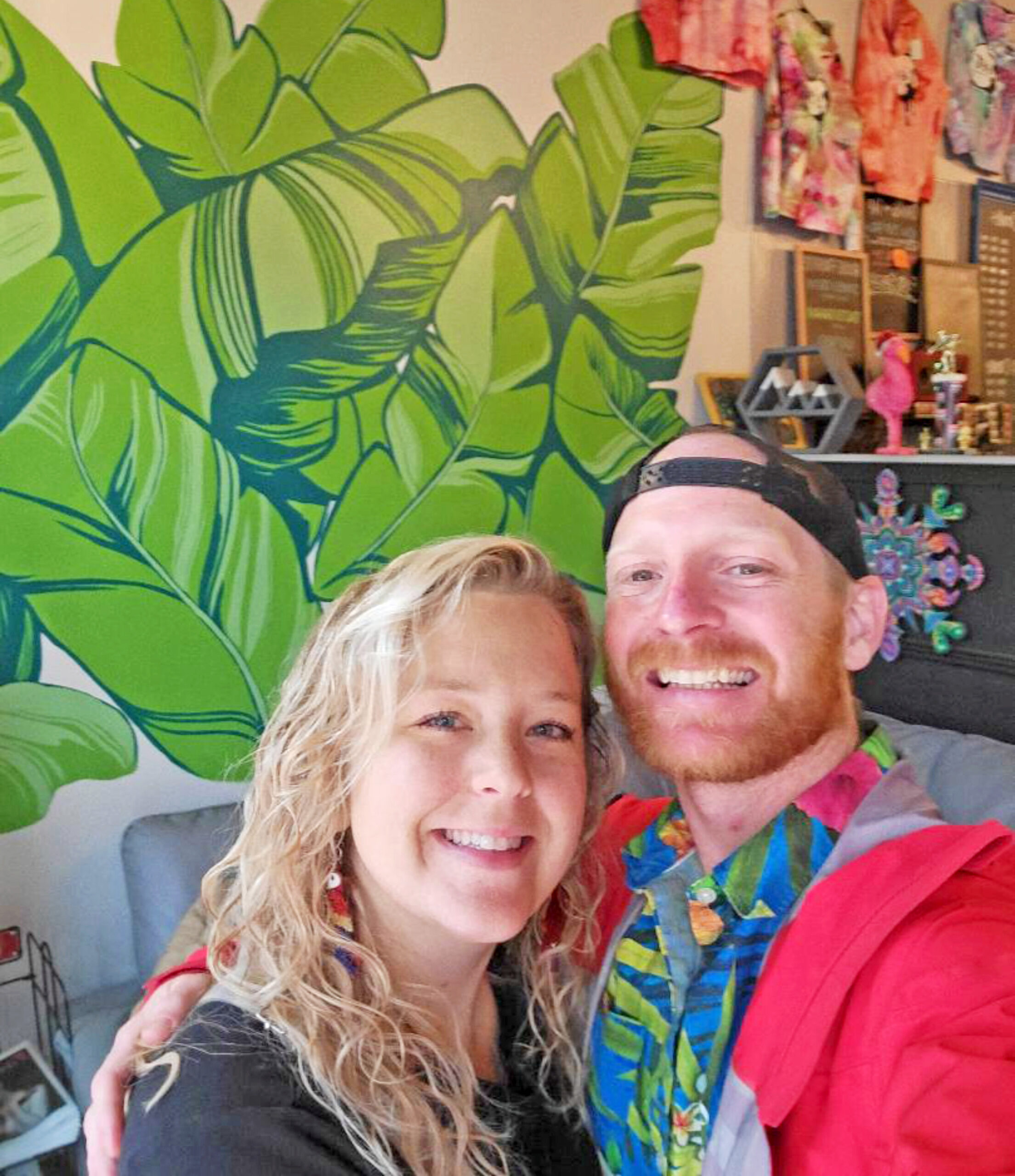 Courtesy photo. Katie and Justin Snyder, owners of The Loft Espresso, stand in front of one of the murals she painted for the café.