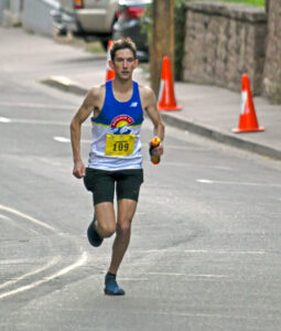 Photo by Bryan Oller. Jonathan Aziz runs toward the finish line on his way to winning the Marathon.
