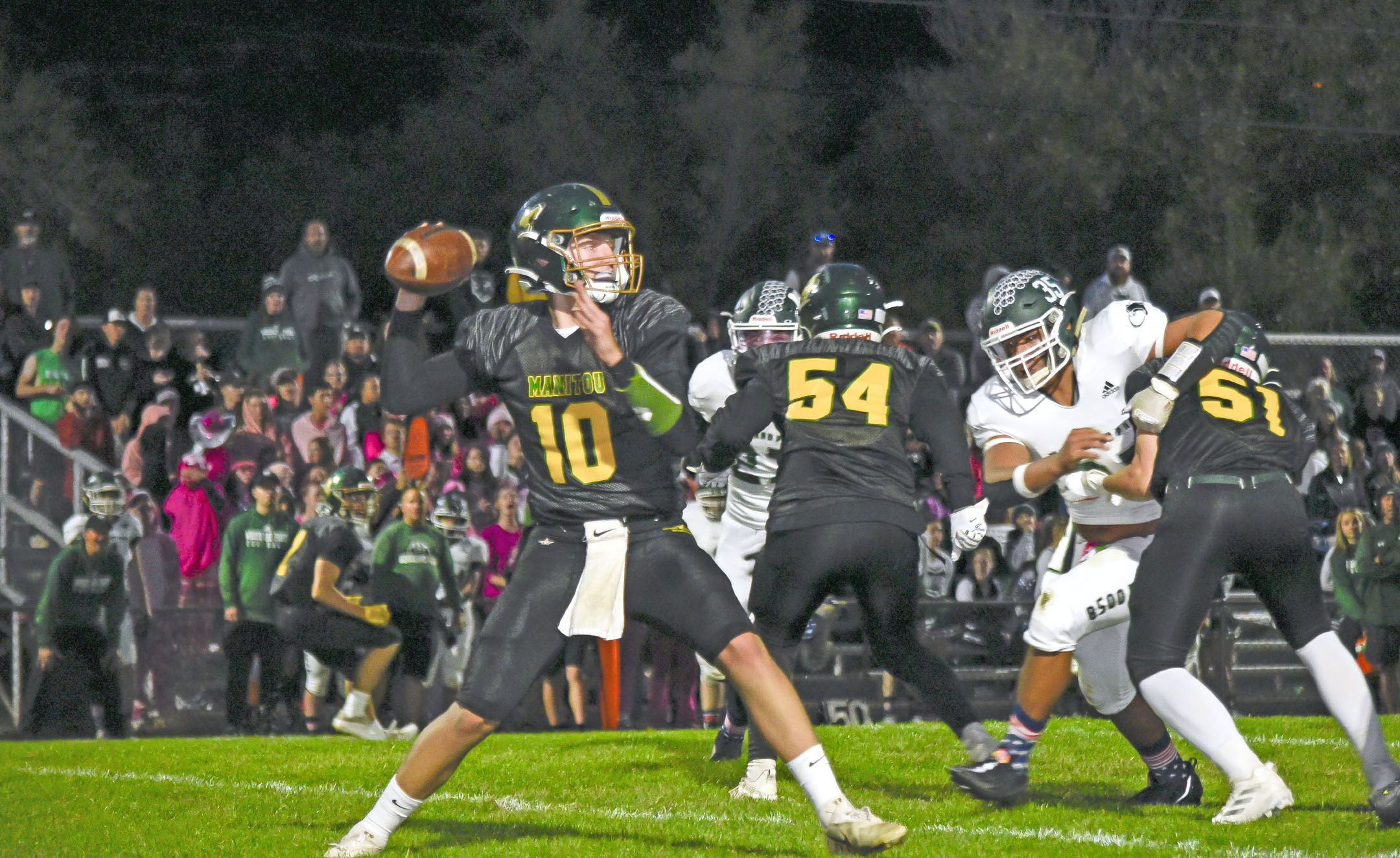 Photo by Bryan Oller. Nate Gentzel passes during the Mustangs’ Sept. 30 game. Jarrin Hall and Ashur Lavigne are in the background.