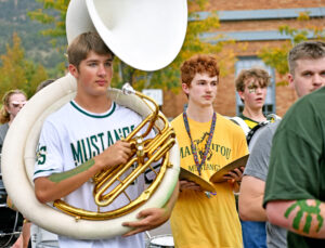 band students  Patrick Mead-Clark, left, Jason Jones and Becket Wendell-Evans march with alumnus Taylor Weimer, Manitou Springs Middle School band teacher, right.
