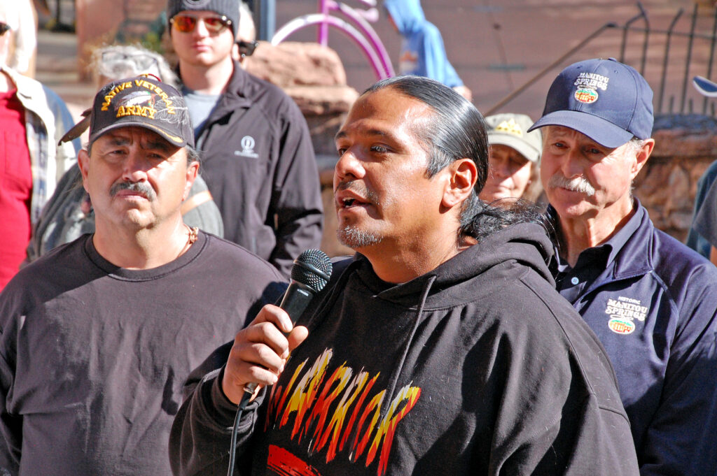 Photo by Rhonda Van Pelt.  Christopher Tabbee, a Ute councilman at the Uintah and Ouray Reservation in Utah, speaks near the Ute Trail marker on Sunday, Oct. 9. Behind him are John Freyta, a Taos Pueblo/Apache, left, and Mayor John Graham.