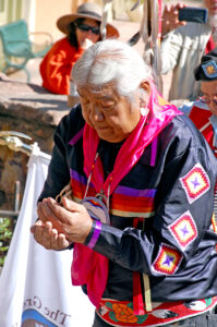 Photo by Rhonda Van Pelt. Kenny Frost, a Southern Ute, cups tobacco in his hands during a ceremony at the rock marking the east end of the Ute Trail, in the 900 block of Manitou Avenue. The city of Manitou Springs presented tribal representatives with gifts including tobacco.