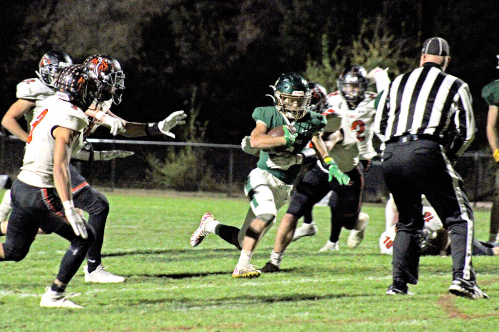 Photo by Daniel Mohrmann. Tyler Maloney runs through the La Junta defense during the first half of Manitou’s Oct. 21 loss to the Tigers.