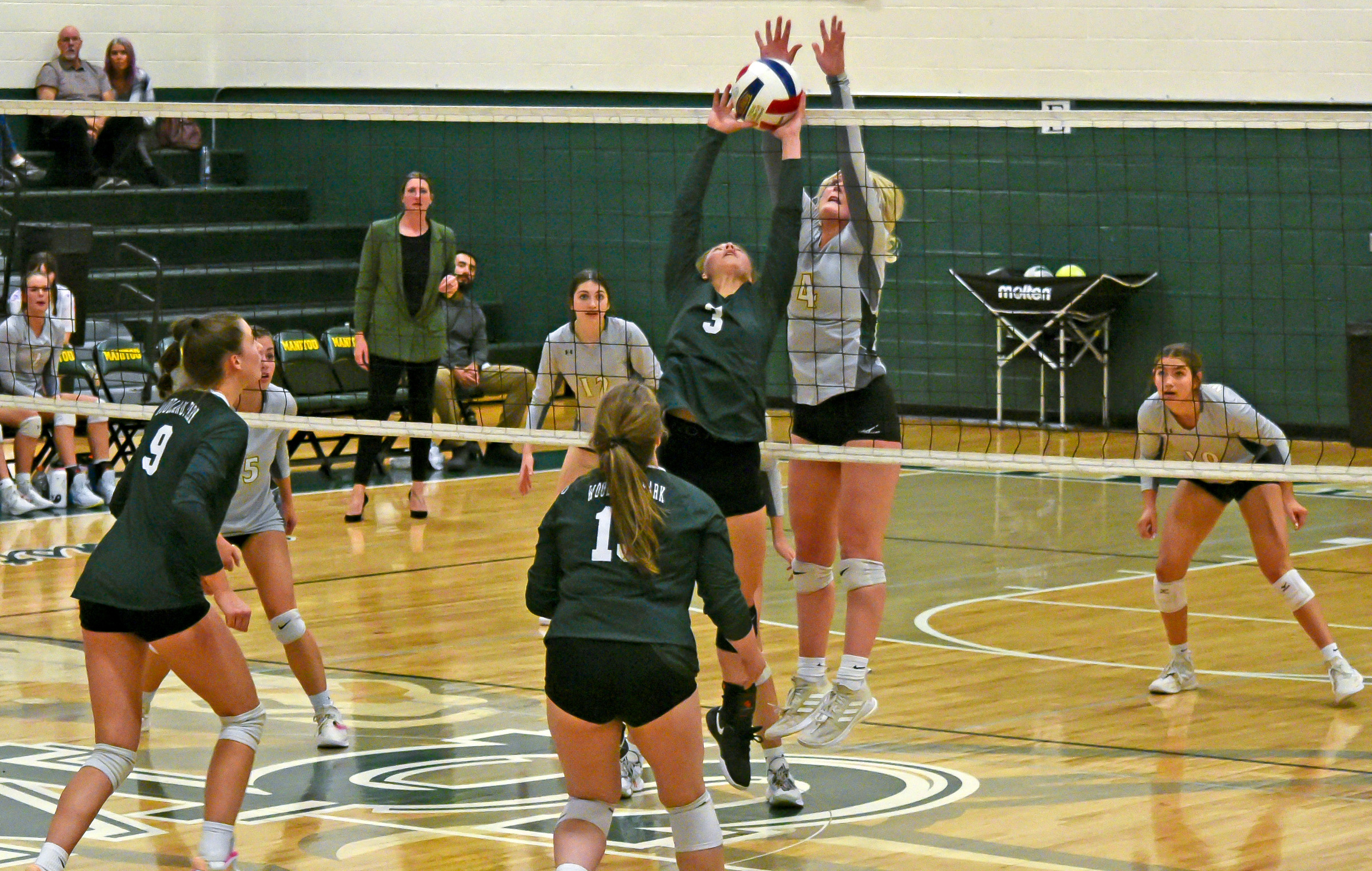 Ayla Flett goes for the block during the Mustangs’ match against Woodland Park on Oct. 13. Teammates (also in light shirts) Lily Glass, Cassidy Blechman and Grace Allen watch to see what happens. Photo by Bryan Oller