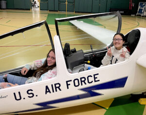 Photo Courtesy of Manitou Springs School District 14. Emily Mason and Kaitlyn Norfleet try out the glider cockpit.