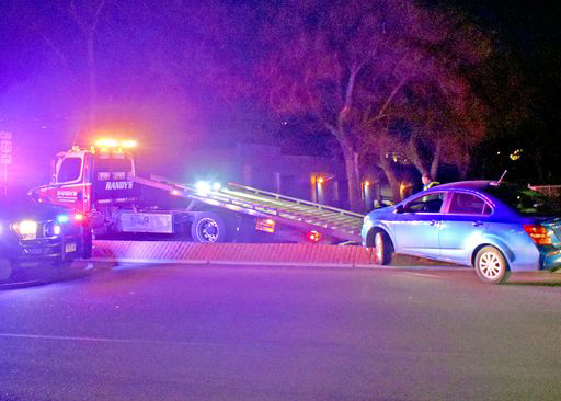 Photo by Rhonda Van Pelt. A tow truck prepares to take away a vehicle that was accidentally driven onto the raised median in the 100 block of Manitou Avenue on Friday, Dec. 9. MSPD investigated the accident; the driver and his passenger were not injured.