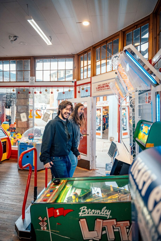 Two people standing in front of an arcade machine
