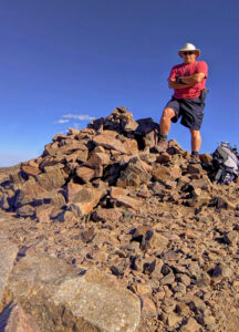 Hiking Bob stands on the West Peak summit. 